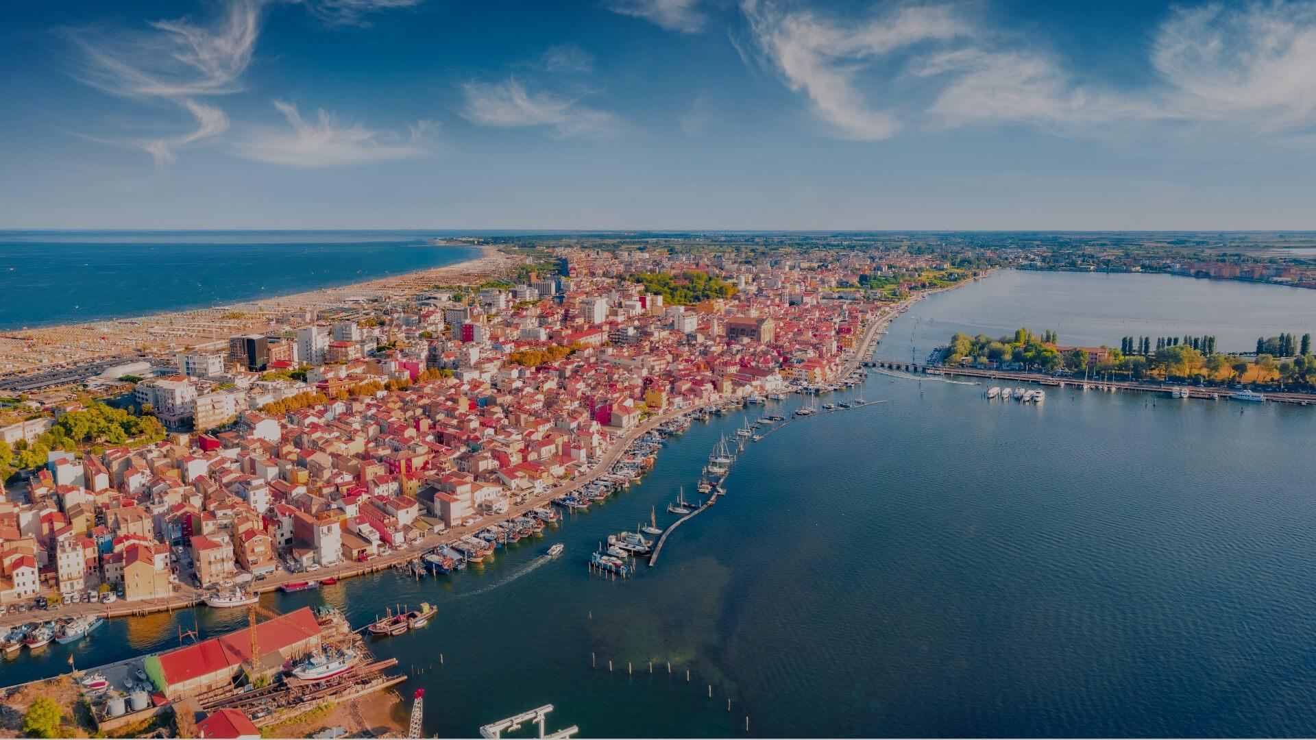 Aerial view of a coastal city, vibrant colors and sparkling sea.
