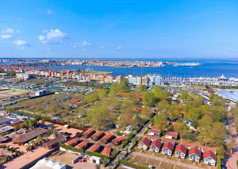 Aerial view of a colorful coastal city, blue sea, and clear sky.